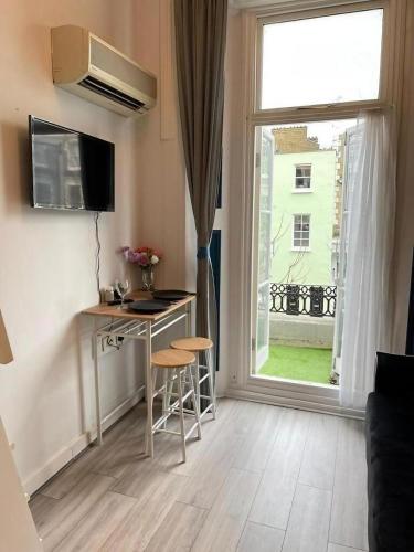 a small apartment with a desk and a window at Portobello Road Artistic Studios in London