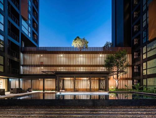 a building with a pool in front of it at The Base Height Phuket in Phuket