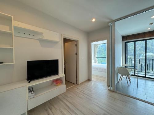 a living room with a flat screen tv sitting on a shelf at The Base Height Phuket in Phuket