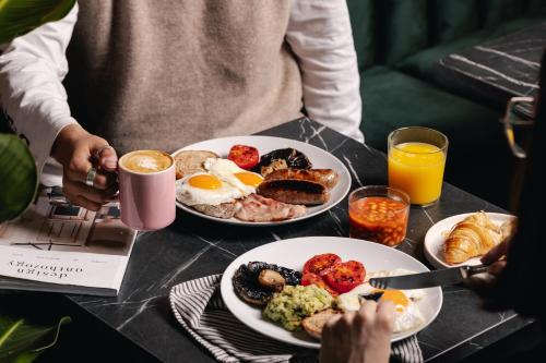 uma mesa com dois pratos de comida para o pequeno almoço em Native Kings Wardrobe, St Pauls em Londres
