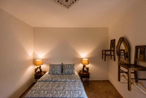 ein Schlafzimmer mit einem Bett mit zwei Lampen und einem Spiegel in der Unterkunft Unique Home In Historic Centre in Lagos