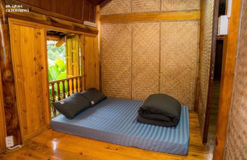 a bed in a small room on a porch at Expeditions home in Ha Giang