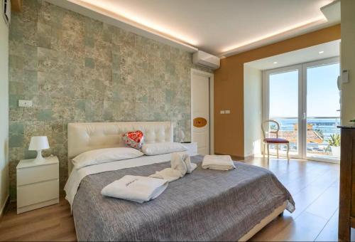 a bedroom with a large bed with towels on it at Vista Mare Apartments in Giardini Naxos
