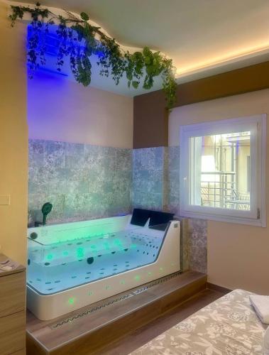 a bath tub in a room with a window at Vista Mare Apartments in Giardini Naxos