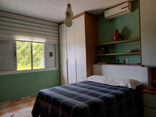 una camera da letto con un letto con una coperta scozzese blu di Represa de Igaratá Yellow House a Jacareí