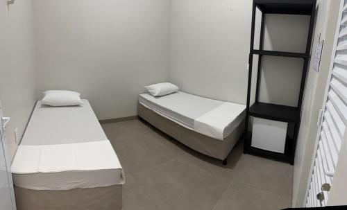 En eller flere senge i et værelse på WEL Home - Suítes - Próximo ao HC UFU