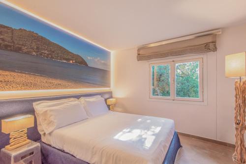 a bedroom with a bed with a painting on the wall at Resort Riva Degli Etruschi in San Vincenzo
