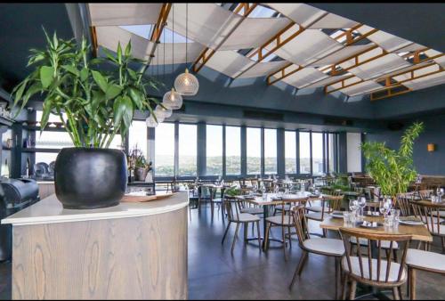 Trilogy studio apartment 831 في بريتوريا: مطعم به طاولات وكراسي ونوافذ كبيرة