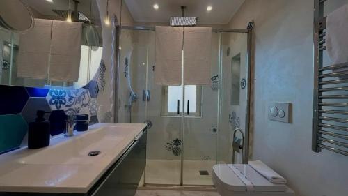 een badkamer met douche, wastafel en toilet bij Olimpia in Arma di Taggia