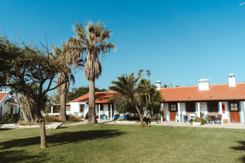 ein Haus mit Palmen vor einem Garten in der Unterkunft Monte Meu in Odemira