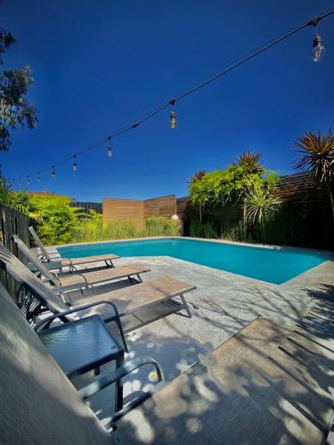 a swimming pool with a group of chairs next to it at Santa Teresita Boutique Hotel in San Fernando