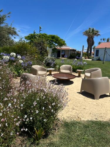 eine Terrasse mit Stühlen und einem Tisch und einem Tisch mit Blumen in der Unterkunft Monte Meu in Odemira