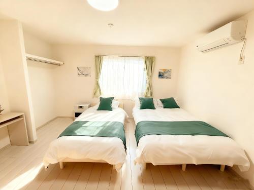 two beds in a room with a window at Niseko Yotei Vista in Kutchan