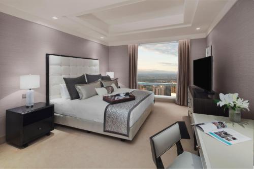 a bedroom with a large bed and a large window at Shangri-La Residences The Fort, Manila in Manila