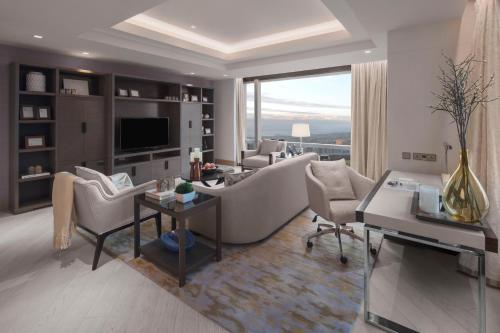 a living room with a couch and chairs and a tv at Shangri-La Residences The Fort, Manila in Manila