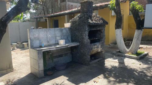 un horno de piedra frente a un edificio en El Gringo Banheiro Compartilhado, en Cabo de Santo Agostinho