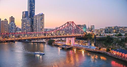 a bridge over a river with a city in the background at InterContinental Brisbane by IHG in Brisbane