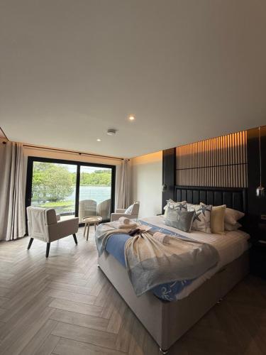 Un dormitorio con una cama grande y una ventana grande en The Inn on the Loch, en Castle Douglas