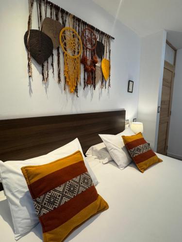 a bedroom with a bed with pillows and a painting on the wall at CASA CRISTOBAL Centenario in Cusco