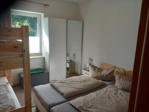 een slaapkamer met twee stapelbedden en een raam bij Ferienwohnungen Albinshof in Krien