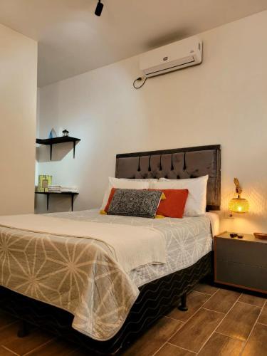 a bedroom with a large bed with orange and white pillows at Casco histórico- Estación 1501 Duplex in Juticalpa