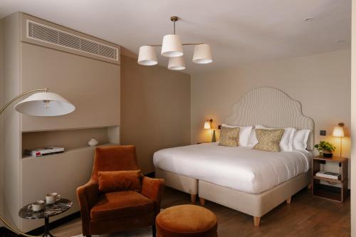 a bedroom with a white bed and a chair at Native Kings Wardrobe, St Pauls in London