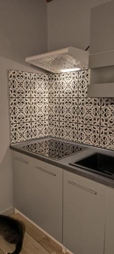 a kitchen with a black and white tiled wall at Willa Baśka in Chańcza