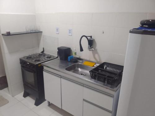 イリェウスにあるAP aconchego de Ilhéusのシンクとコンロのある小さなキッチン