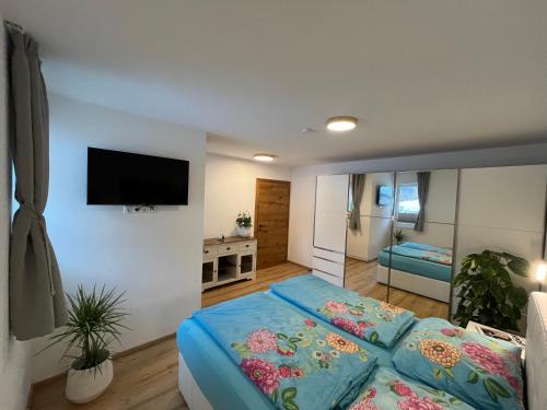 a bedroom with a bed and a flat screen tv at Ferienappartement Sieger in Großkirchheim