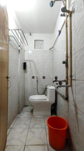 a bathroom with a toilet and a bucket in it at Amaravati homestay in Guwahati