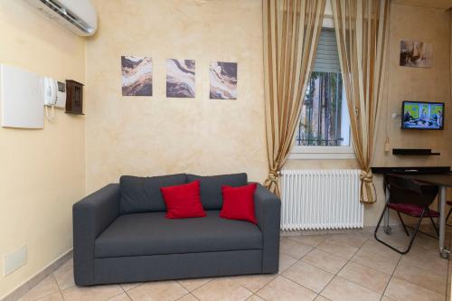 sala de estar con sofá y 2 almohadas rojas en Il Rifugio Dei Bizantini, en Rávena