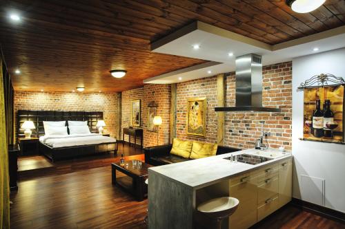 a kitchen and living room with a couch and a bed at Apartamenty Chleb i Wino Strumykowa in Toruń