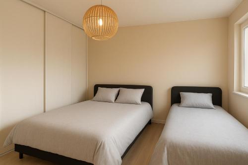 zwei Betten nebeneinander in einem Zimmer in der Unterkunft Maison de Plain-pied à 15 mins de Compiègne 