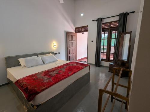 ミリッサにあるWayside Mirissaの赤い毛布が掛けられた大きなベッドのある寝室