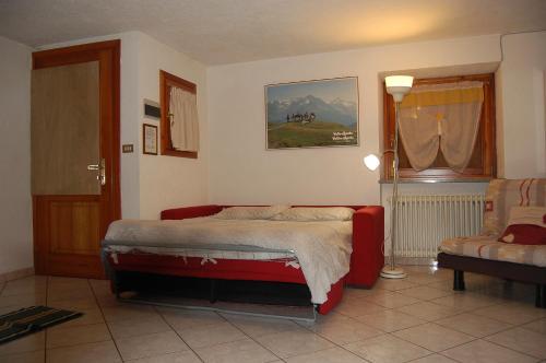 a bedroom with a bed and a chair and a window at Case Gran Paradiso Rhemes Saint Georges Vieux in Rhemes-Saint-Georges