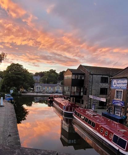 a group of boats are docked on a river at Spinners View - NEW Renovated Apartment - Central Skipton & Parking in Skipton
