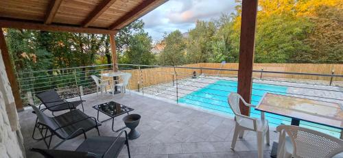 a patio with a table and chairs and a swimming pool at Secret Garden in Grottolella