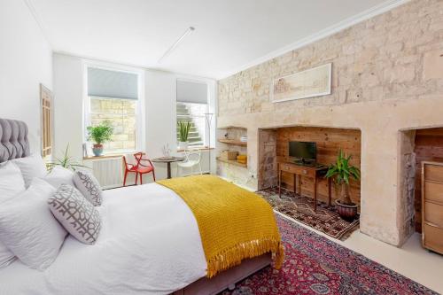 a bedroom with a large bed and a fireplace at The Georgian Studio in Bath