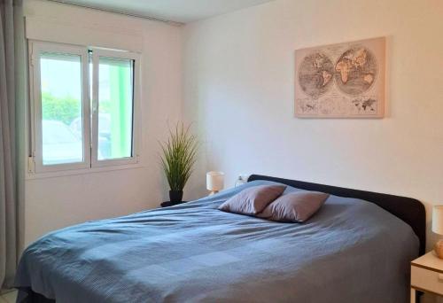 1 dormitorio con cama azul y ventana en Apartamento Acuarela by Family Homes, en El Verger