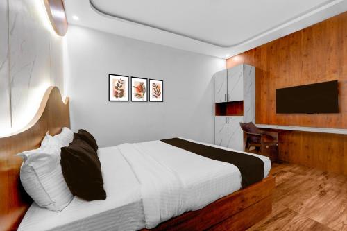 Vānivilāsa PuramHotel O Udaya Residency的卧室里有一张床和一台电视机