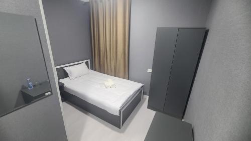 a small bedroom with a small bed and a cabinet at Imran Hotel Navoiy in Navoi