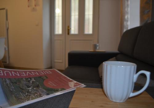 La Blanche des Marais, maison de ville في Picauville: وجود كوب قهوة على طاولة مع المجلة