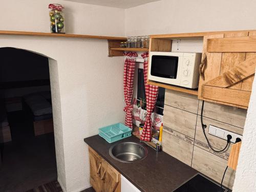 una piccola cucina con lavello e microonde di Chalupa M&P 2 a Bešeňová