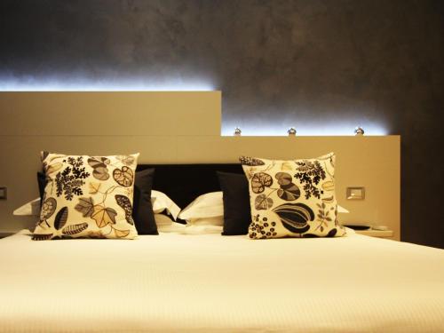 um quarto com uma cama com almofadas e uma cabeceira em Verona Center em Verona
