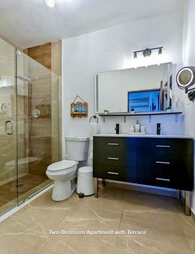 a bathroom with a toilet and a sink and a shower at Ocean Front Apartments in Arecibo