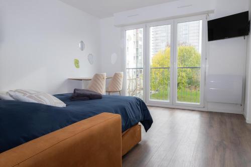 a bedroom with a bed and a large window at Studio le Goya - Cosy & Lumineux in Thionville