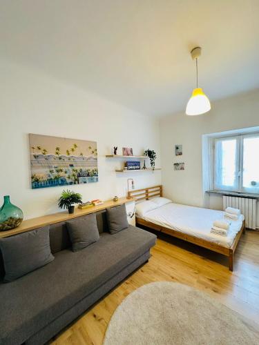 una sala de estar con un sofá y una cama en Luminoso appartamento con garage privato gratuito, en Milán