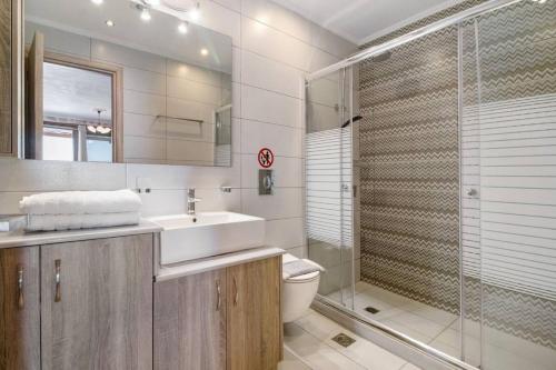 ein Badezimmer mit Toilette, Waschbecken und Dusche in der Unterkunft VillasGoudis Evelynn in Tsoukaladhes