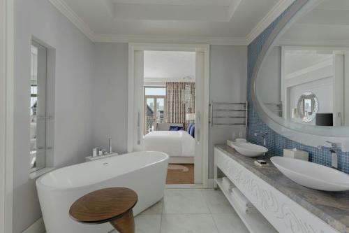 a bathroom with two sinks and a tub and a mirror at Pik Palace, Shahdag, Autograph Collection in Shahdag