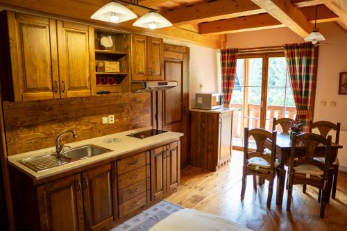 a kitchen with a sink and a table with chairs at Zrub Raj in Liptovský Ján